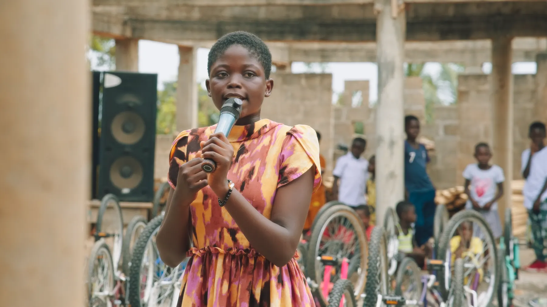A girl giving a speech in front of the bikes