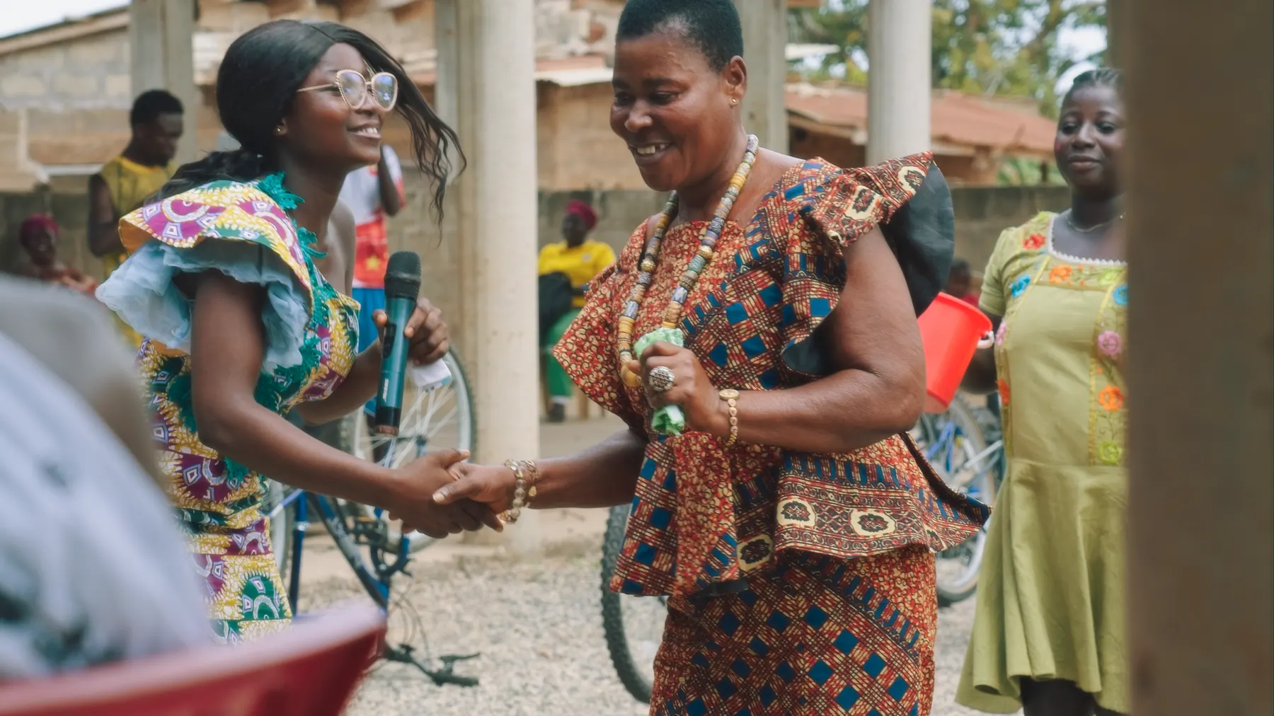 Two women shaking hands during the handover ceremony