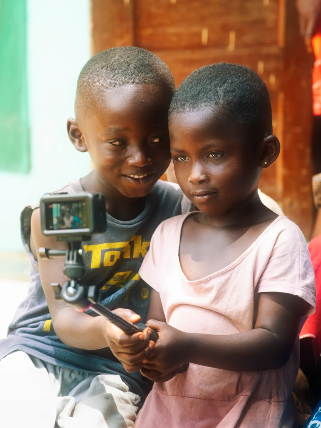 Two young kids holding an action camera