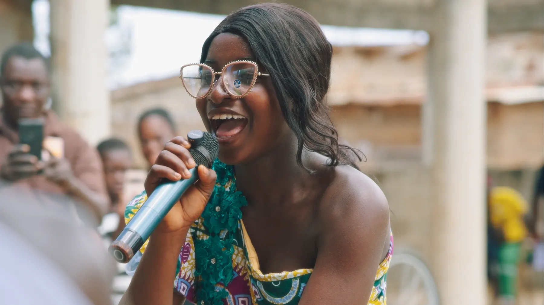 A young woman laughing as she speaks into a microphone